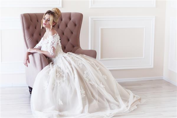 عروس جوان زیبا مدل موی عروسی موهای بلوند لباس عروس آرایش و دسته گل عروس شوت داخلی