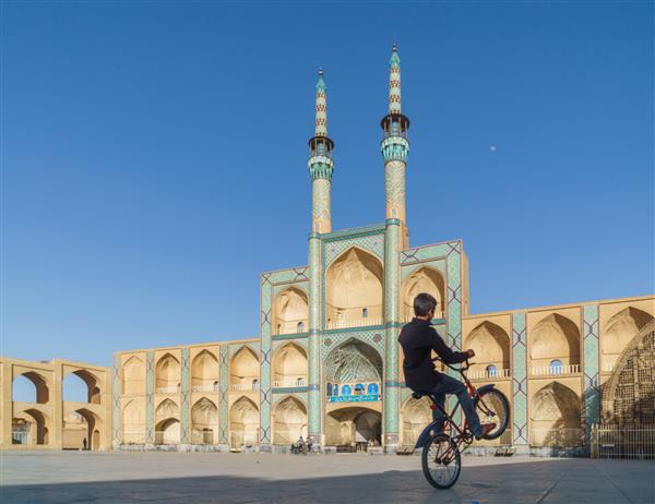 یزد ایران پسر دوچرخه سواری مقابل مجتمع امیر چخماق یزد ایران 11 ژوئن 2017