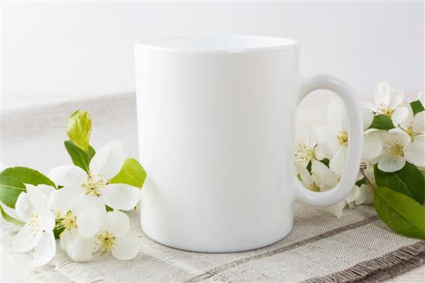 ماکت لیوان قهوه سفید با شاخه شکوفه درخت سیب ماکت لیوان خالی برای ارتقای طراحی