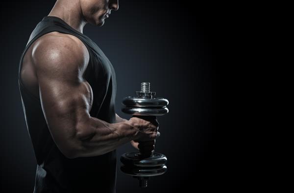 بدنساز قوی با عضلات دلتوئید عالی شانه ها عضله دوسر سه سر و سینه نمای نزدیک یک مرد تناسب اندام قدرتی مرد خوش تیپ ورزشکار قدرتمند در تمرین پمپاژ کردن عضلات با دمبل