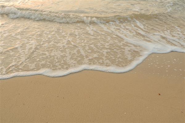 موج نرم در ساحل شنی زمینه