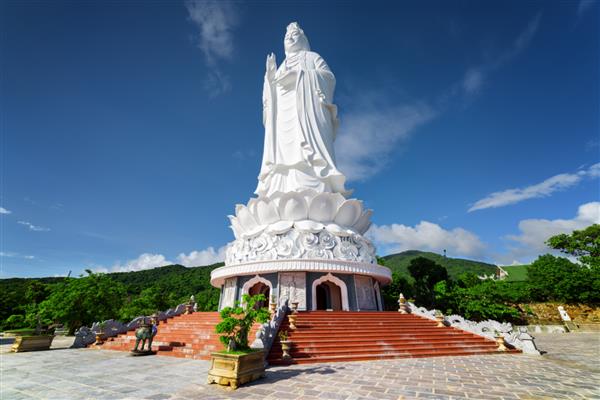 منظره باشکوه بانو بودا بودیساتوای رحمت در بتکده Linh Ung Danang Da Nang ویتنام مجسمه سفید بودا در پس زمینه آسمان آبی