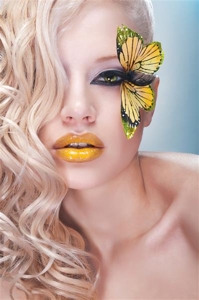 زن بلوند فرفری با پروانه زرد روی مژه ها