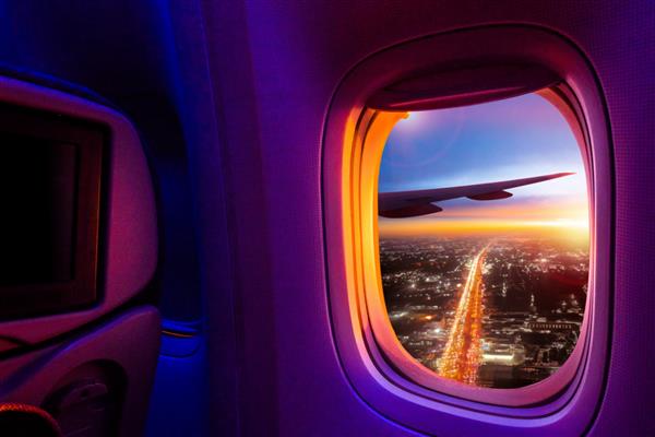 منظره زیبای شهر غروب خورشید از پنجره هواپیما مسیر ذخیره تصویر برای پنجره هواپیما