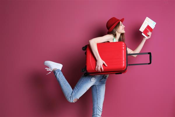 مسافر زن با چمدان در پس زمینه رنگی