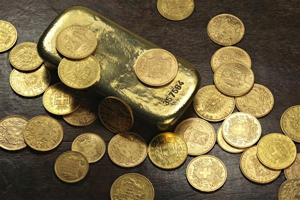 انواع سکه های طلای گردشی اروپایی از قرن 19 20 دور یک شمش طلا در زمینه چوبی روستایی