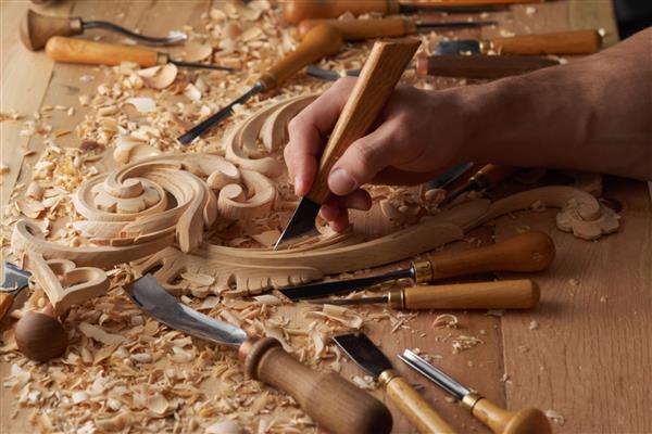نجاری و کنده کاری روی چوب دستان نجار از اسکنه استفاده می کند کارشناس ارشد منبت کاری در حین کار مردی که با ابزار منبت کاری کار می کند