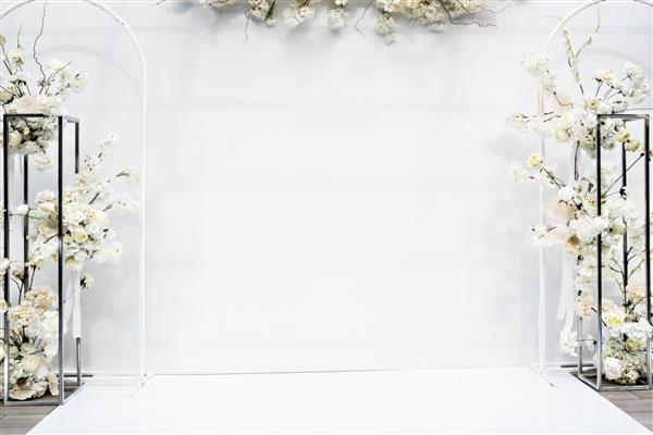 دیوار عکس سفید محل طاق سفید گلبرگ تزئین شده گل پذیرایی عروسی برای مراسم مجلل در رستوران تالار فضای کپی مفهوم جشن جشن دکوراسیون مد روز در منطقه ضیافت