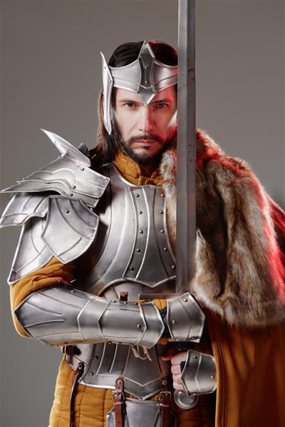 پادشاه شوالیه خوش تیپ قرون وسطایی با زره پوش که شمشیر در دست دارد