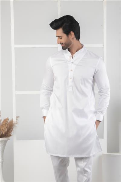 کراچی پاکستان - 14 ماه مه 2022 مرد پاکستانی با لباس سنتی لباس خواب کورتا مدل مد مرد در شروانی ژست گرفتن در استودیو مفهوم مد عروسی