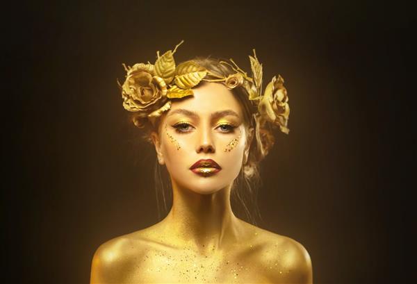 پرتره ملکه زن فانتزی زیبایی چهره در رنگ طلایی پوست درخشان طلایی مدل مد دختر الهه تصویر لوازم جانبی جواهرات تاج گل رز پر زرق و برق آرایش متالیک حرفه ای