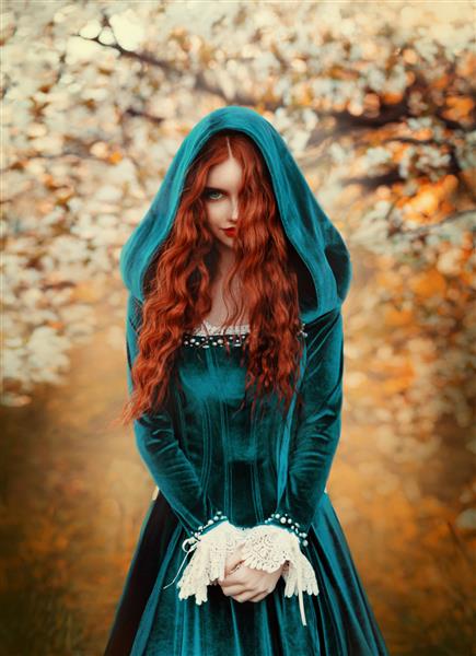 پرتره زن مو قرمز فانتزی عرفانی که به دوربین نگاه می کند دختر شاهزاده خانم لباس ویکتوریایی قرون وسطایی سبز آبی ملکه بانوی پر زرق و برق موهای فرفری بلند قرمز که در باد پرواز می کند جنگل پاییزی