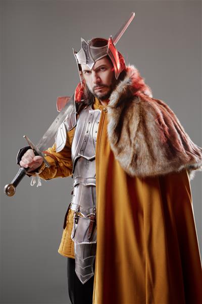 پادشاه شوالیه خوش تیپ قرون وسطایی با زره پوش که شمشیر در دست دارد