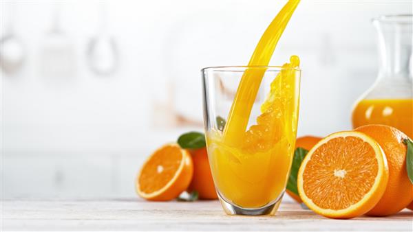 ریختن آب پرتقال در لیوان آب پرتقال تازه با میوه پرتقال در آشپزخانه فضای خالی برای متن مفهوم رژیم غذایی سالم