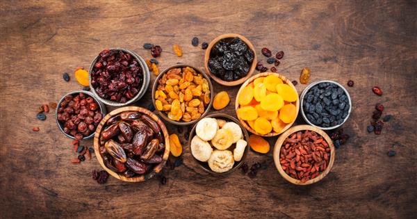 ظرف میوه خشک میان وعده غذایی سالم ترکیب ارگانیک خشک شده از زردآلو انجیر کشمش خرما و غیره روی میز چوبی نمای بالا