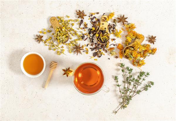 فنجان میوه تازه دم شده و چای گیاهی با عسل و زنجبیل مفهوم سالم دارویی برای کمک به پیشگیری از آنفولانزا سایه های سخت ترند