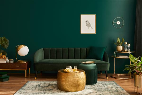 اتاق نشیمن لوکس در خانه با طراحی داخلی مدرن مبل مخملی سبز میز قهوه خوری پوف دکوراسیون طلایی گیاه چراغ فرش قاب پوستر ماکت و لوازم جانبی زیبا قالب