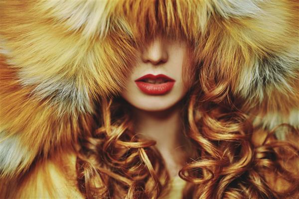 مدل کت خز پرتره کلوزآپ زنی زیبا با موهای قرمز و لب های قرمز در کت خز روباهی مجلل مد زیبایی زمستانی