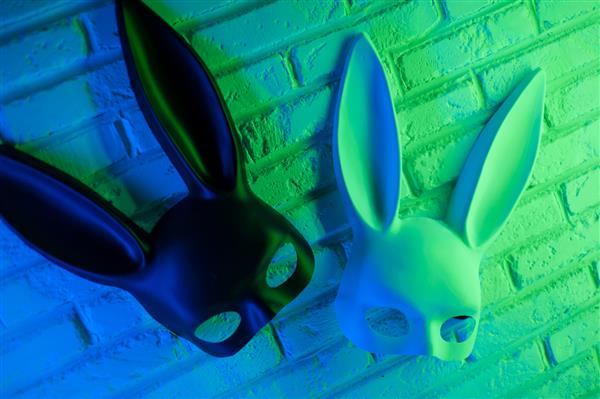 ماسک خرگوش سیاه و سفید روی پس‌زمینه دیوار بافت سفید در آبی سبز نئون
