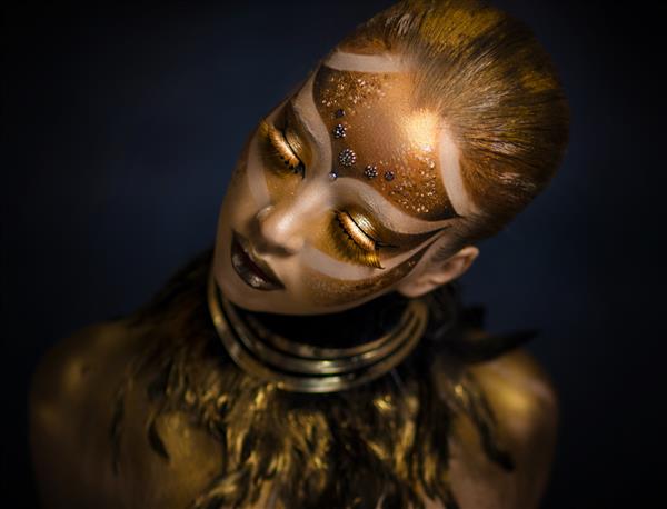 نقاشی بدن قومی ماسک کارناوال مجسمه طلایی نگهبان قبیله خورشید بدن طلایی دختری با رنگ طلایی آرایش فانتزی