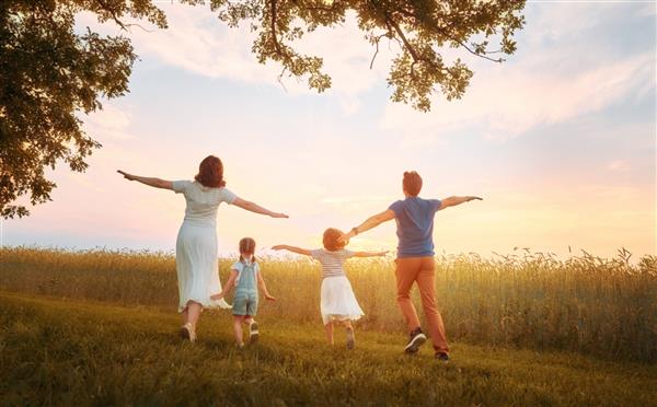 خانواده شاد در پیاده روی تابستانی قدم زدن مادر پدر و دختر در پارک و لذت بردن از طبیعت زیبا