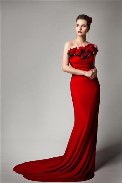 زن با لباس شب قرمز با گل رز پرتره زیبایی مدل مد شیک با لباس مجلسی بلند پرتره استودیویی