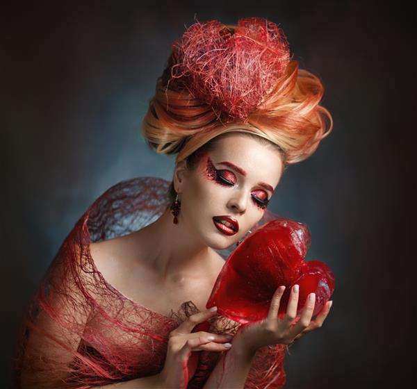 روز ولنتاین دختر زیبا با قلب قلب قرمز یخی نماد عشقدختر جوان بسیار زیبازیبایی مو قرمزقلب قرمز یخی در دستان یک دختر بانوی قرمزپوش