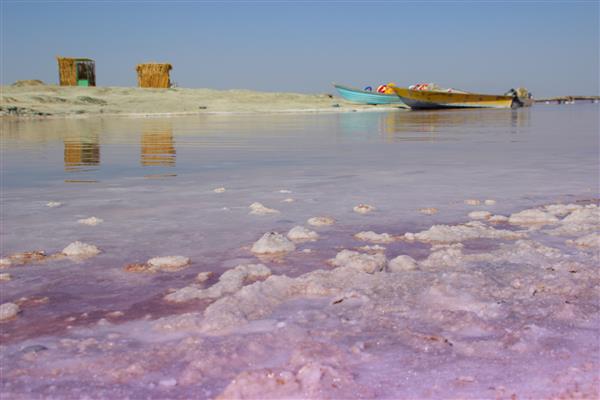 دریاچه ای زیبا با آب صورتی کریستال های سفید نمک در آب قابل مشاهده است جاهای دیدنی و طبیعی ایران