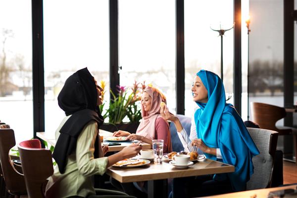 زنان جوان مسلمان در حال غذا خوردن در کافه