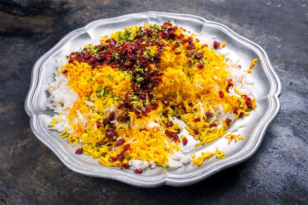 برنج زعفرانی بخارپز سنتی ایرانی با بربری و پسته در نمای نزدیک در بشقاب اسپند