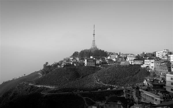Kurseong Darjeeling-05 Mar 19 نمای سیاه و سفید از برج تلویزیون در بالای تپه در شهر Kurseong از هتل آمارjeet در کنار جاده گاری تپه ای