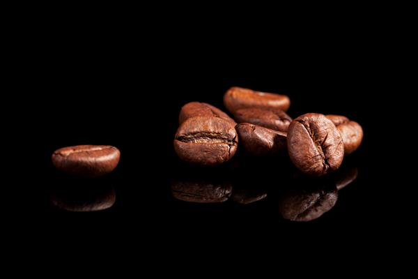 دانه های قهوه معطر مجلل در زمینه مشکی مفهوم قهوه لوکس