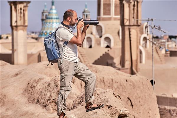 یک مسافر انفرادی در یک سفر فردی مستقل در یک شهر قدیمی عکس می گیرد کاشان قدیمی cyti ایران