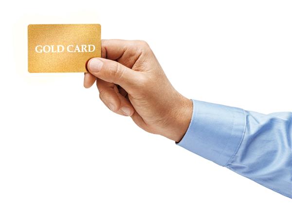 دست مردی در پیراهن که کارت اعتباری طلایی را در پس زمینه سفید نگه داشته است محصول با وضوح بالا نزدیک