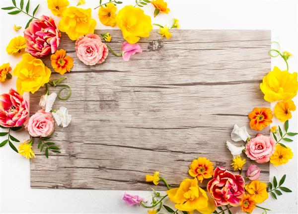 ترکیب گل در زمینه چوبی با گل های بهاری مفهوم عید پاک با کپی اسپاس تخت خوابیده نمای بالا