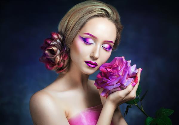 دختر زیبایی که یک گل رز با گل های صورتی در دست دارد
