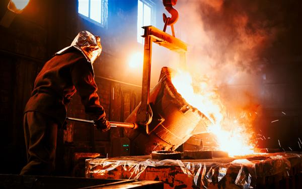کارگران در کارخانه متالورژی فعالیت می کنند فلز مایع در قالب ها ریخته می شود کارگر کنترل ذوب فلز در کوره ها