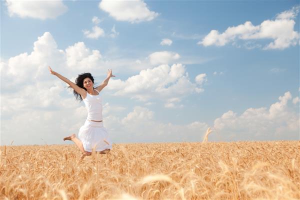 زن شادی که در گندم طلایی می پرد