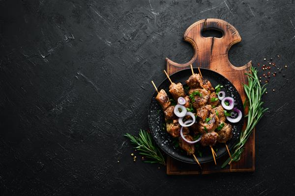 سیخ های آبدار گوشت در بشقاب سیاه باربیکیو کباب نمای بالا فضای کپی رایگان