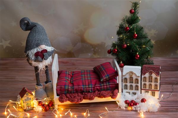 گهواره برای عکاسی نوزاد گنوم و درخت کریسمس کنار تخت