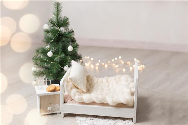 گهواره برای عکاسی نوزاد درخت کریسمس کنار تخت