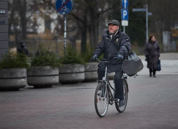 ریگا لتونی - 17112018 مرد با کیف روی دوچرخه در ریگا