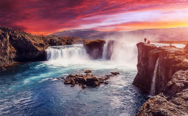 آبشار گودافوس با آسمان رنگارنگ چشمگیر در هنگام غروب خورشید مناظر طبیعت ایسلند مناظر شگفت‌انگیز با نوردهی طولانی از نقاط دیدنی ایسلند تصاویر خلاقانه بهترین مکان ها برای عکاسان