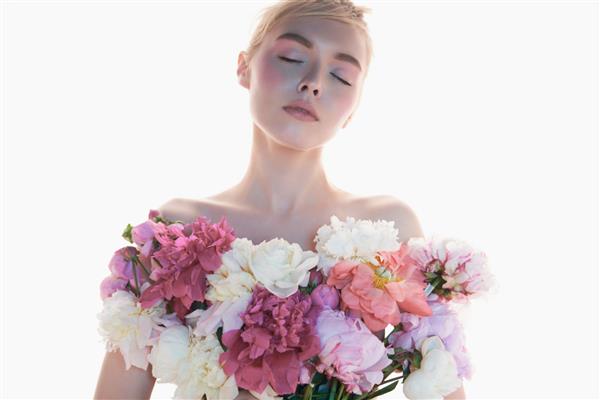 زن جوان زیبا با دسته گل رز پرتره هنری بلوند سکسی با گل های رنگارنگ میکاپ هنری حرفه ای دختر زیبا جدا شده در پس زمینه سفید