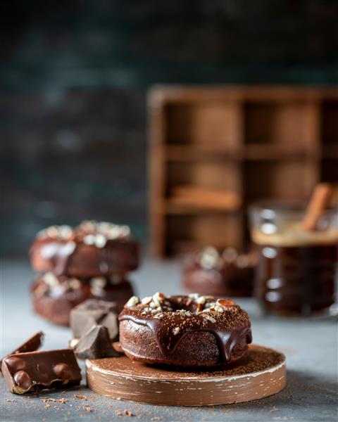 دونات شکلاتی با لعاب شکلاتی آجیل و قهوه روز ملی دونات پخت خانگی فوکوس انتخابی فضای کپی