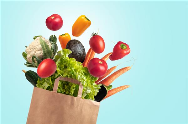 کیسه قابل بازیافت سبزیجات تازه در پس زمینه آبی آسمان تابستان