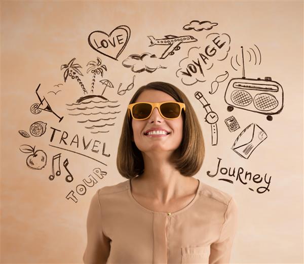 زن مثبت خندان با عینک آفتابی برای تعطیلات خود برنامه ریزی می کند طرح هایی از برنامه های سفر او به اطرافش