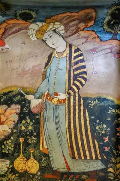 پرتره مرد صفوی با لباس راه‌راه و ظرف شراب در فضای باغ (مکتب اصفهان)