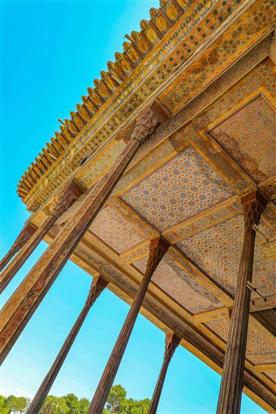 نمای پرسپکتیو از ستون‌های مرتفع و سقف ایوان چهلستون در برابر آسمان آبی