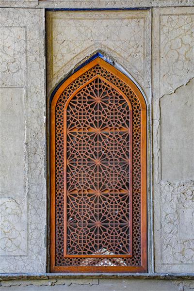 پنجره چوبی مشبک با طرح گره‌چینی و دیوار سنگی چهلستون برای چاپ دکوراتیو